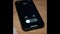 Black mobile phone screen starts to glow after an incoming call from the boss. The smartphone lies on a wooden table