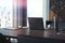 Black modern laptop on wooden table in contemporary office, 3d rendering.