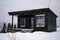 Black modern tiny cabin with mountain view in winter