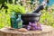 Black mortar with sage herbs, glass bottles of essential oil