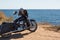 Black motorcycle on beautiful seacoast and blue sky onward. Prairie, steppe, summer.