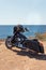 Black motorcycle on beautiful seacoast and blue sky. Prairie, steppe, summer.