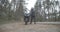 Black motorcycle standing on roadside as confident woman in pink and black helmet approaching to motorbike and sitting