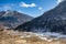 Black mountain with snow on the top and brown mountain with glacial traces on yellow stone ground at Thangu and Chopta valley.