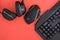 Black mouse, the keyboard, the headphones are isolated on a red background