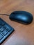 Black mouse and part of keyboard on working desk in office