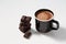 Black mug with hot chocolate served with chunks of dark chocolate