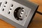 Black multi-socket on wooden table closeup