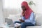 Black muslim graphic designer female working at home with swatches and laptop