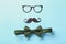 Black mustache, glasses and bow-tie on color background. Happy Father\'s Day celebration