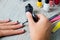 Black nail polish being applied to hand with tools for manicure on background. Beautiful process. Close up.