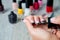 Black nail polish being applied to hand with tools for manicure on background. Beautiful process. Close up.