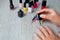 Black nail polish being applied to hand with tools for manicure on background. Beautiful process. Top view. Copy space