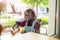 Black non-binary person sitting in an outdoor cafe