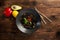 Black noodles with marbled beef on a wooden background