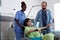 Black nurse transporting pregnant woman in wheelchair