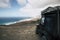 Black off road car parked on the top of a valley with amazing view on a wild beach with nobody - off grid roof tent and adventure