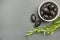 Black olives. Bella di cerignola Italian olives. Colored olives and a sprig of rosemary lie on a black stone countertop