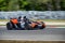 Black and orange fast sports car drives along a racing circuit.