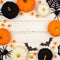 Black, orange and white Halloween frame over white wood