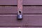 Black padlock on the door of a wooden stand. Locked window with a padlock