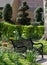 Black painted garden bench photographed in springtime at Eastcote House historic walled garden, Hillingdon UK