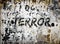 Black painted rustic terror text/word on rusty and weathered destroyed concrete wall background.