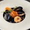 Black pasta Nero with seafood, spaghetti with shrimp, squid and red caviar. Beautiful tasty dish