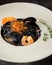 Black pasta Nero with seafood, spaghetti with shrimp, squid and red caviar. Beautiful tasty dish