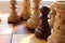 Black pawn stands among white chess figures