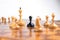 Black pawn surrounded by white chess pieces