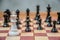 Black pawn surrounded by white chess pieces on a chess board