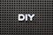 Black pegboard with white letter in word DIY abbreviation of do it yourself