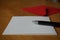 Black pen writing announcement letter with the envelope on the wooden desk