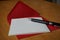 Black pen writing announcement letter with the envelope on the wooden desk