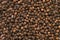 Black peppercorn background. View from above