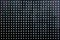 Black perforated steel sheet with round holes, close-up