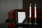 Black photo frame with  candles and red rose on table in funeral home