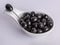 Black pitted olives on a gray background.