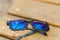 Black pixel sunglasses with blue lenses closeup in a sunny day. Selective focus