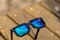 Black pixel sunglasses with blue lenses closeup in a sunny day. Selective focus