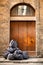 Black plastic bags of rubish piled up outside an old timber door Florence