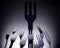 Black plastic fork surrounded by silver cutlery