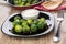 Black plate with brussels sprouts, bowl of mayonnaise and fork