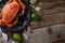 Black plate with cooked king crab served with ice cubes. lime and seashells on rustic wooden background. Delicious meal. Seafood