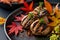 A black plate filled with a delectable assortment of meat and vegetables, creating a colorful and appetizing display, Grilled