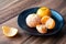 Black plate of satsuma oranges on a rustic wood table