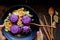 Black plate of violet rice dish with vegetables, delicious vegan meal