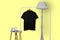 Black polo shirt with wooden hanger hanging on rack display isolated on plain background