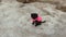 Black poodle dog on ice. Funny cute puppy sitting on icy ground in winter. Dog wearing warm clothing enjoying walk on